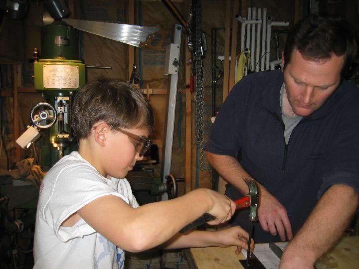 IMG_5087.jpg - I'm using a transfer punch to mark where the holes go.   My neighbor, Matt, is holding the angle iron in place.